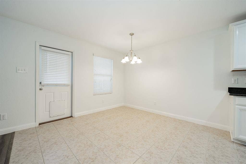 122 Feverbush Drive, Fate, TX 75189 Unfurnished dining area with a chandelier and light tile patterned flooring