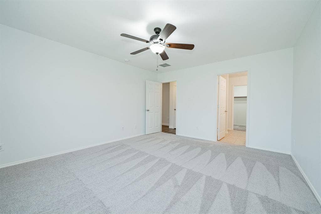 122 Feverbush Drive, Fate, TX 75189 Unfurnished bedroom with light colored carpet and ceiling fan