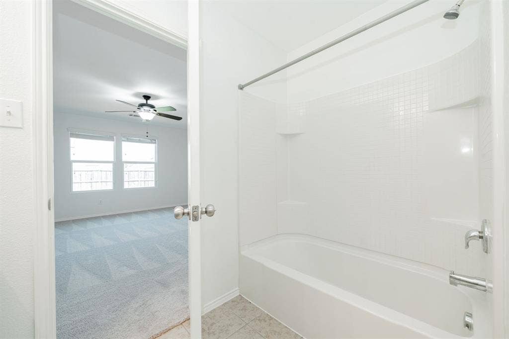 122 Feverbush Drive, Fate, TX 75189 Full bath with bathing tub / shower combination, a ceiling fan, and tile patterned flooring