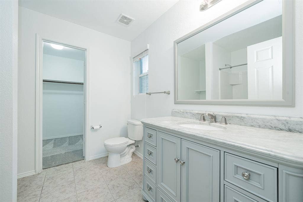 122 Feverbush Drive, Fate, TX 75189 Bathroom featuring vanity, a spacious closet, and tile patterned flooring