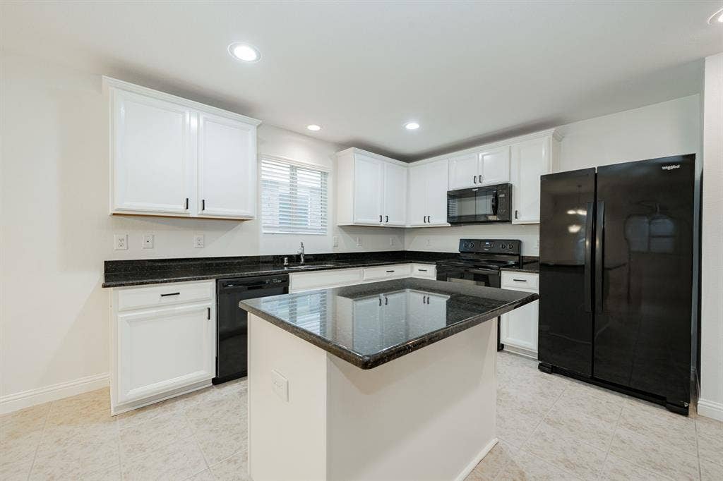 122 Feverbush Drive, Fate, TX 75189 Kitchen featuring black appliances, white cabinets, dark stone countertops, recessed lighting, and a center island