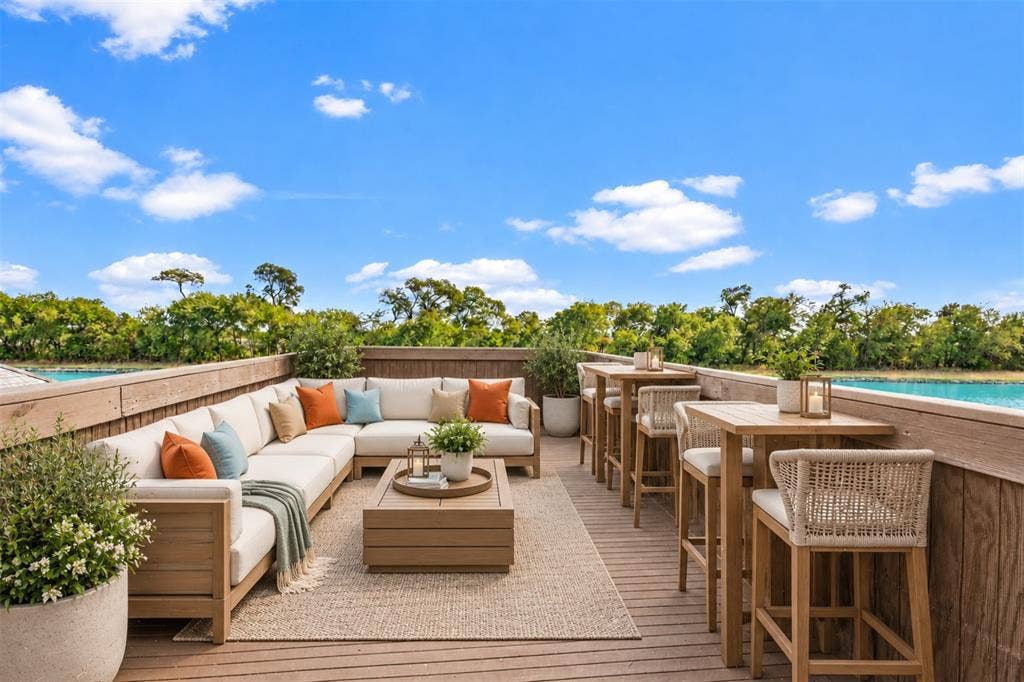 623 Calm Water Cove, Princeton, TX 75407 AI Staged Expansive outdoor deck featuring wood-look flooring, built-in perimeter wall, and water backdrop