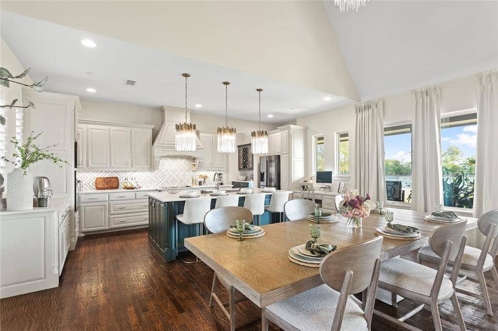 623 Calm Water Cove, Princeton, TX 75407 Spacious open-concept kitchen and dining area featuring a vaulted ceiling and dark wood-finish flooring