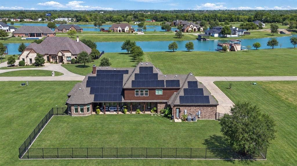 623 Calm Water Cove, Princeton, TX 75407 Brick exterior with multiple solar panel arrays, stone accents, and a covered back patio