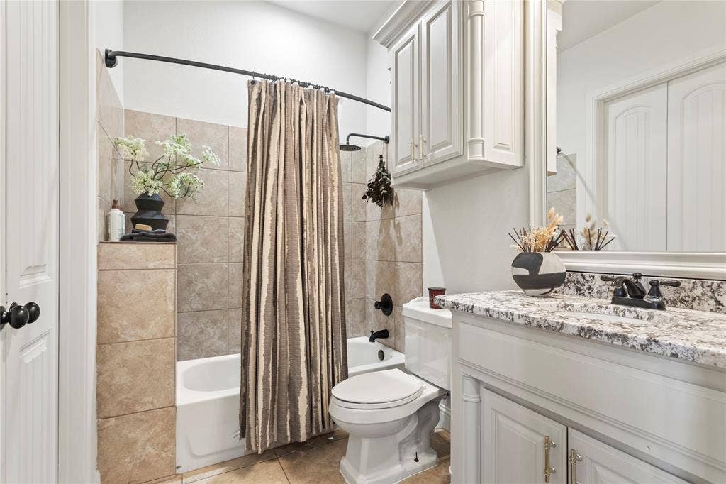 623 Calm Water Cove, Princeton, TX 75407 Bathroom featuring a tiled tub surround, shower with rainfall showerhead, and a vanity with a granite countertop and built-in cabinetry