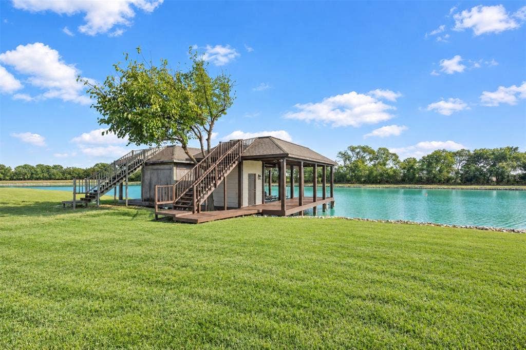 623 Calm Water Cove, Princeton, TX 75407 Expansive grassy area with a waterside gazebo, a boathouse, and an additional covered structure
