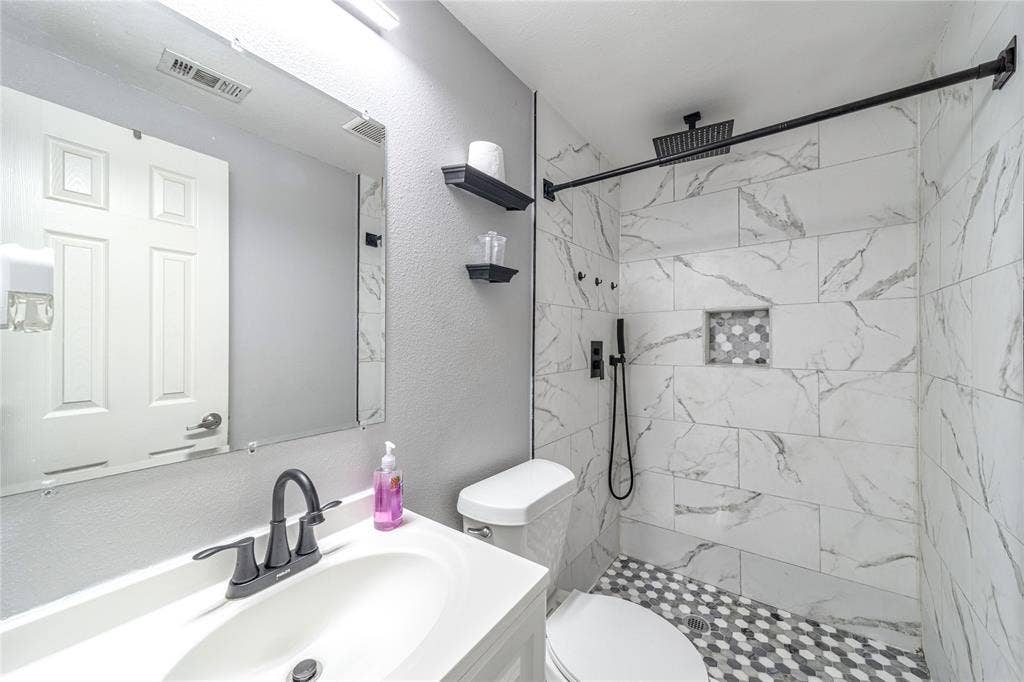 726 Royal Crest, Mesquite, TX 75149 Bathroom with vanity, a marble finish shower, and a textured wall
