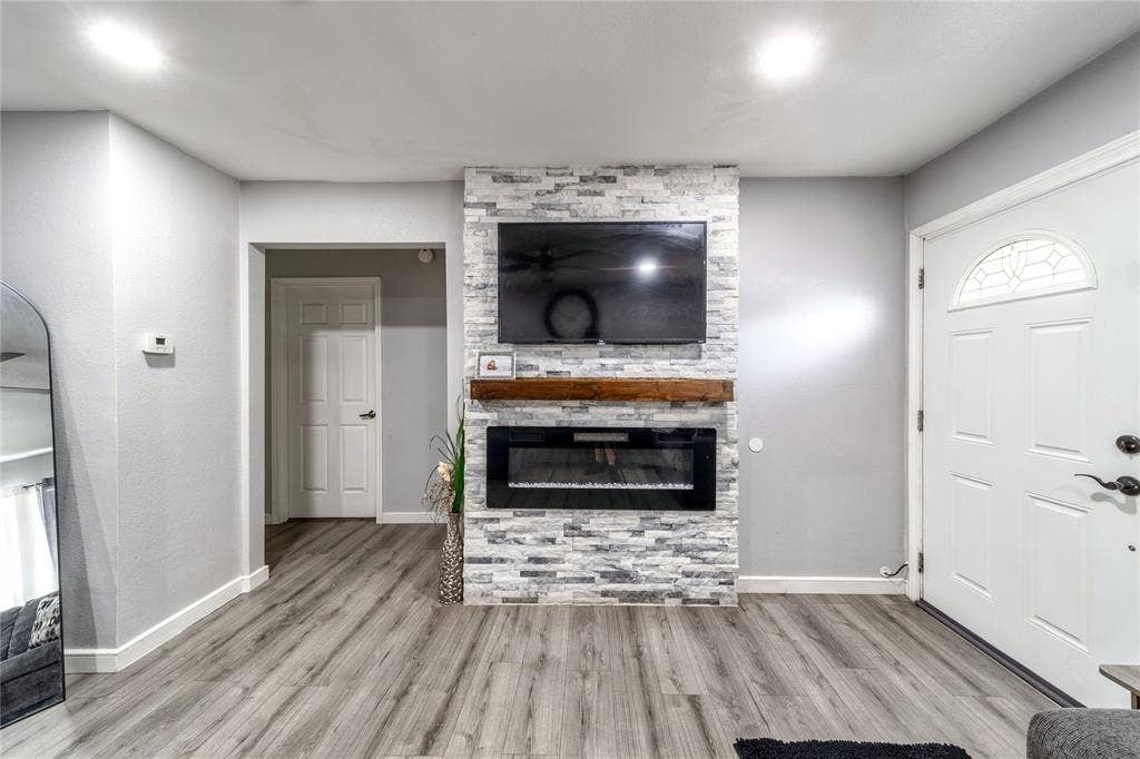 726 Royal Crest, Mesquite, TX 75149 Unfurnished living room featuring a large fireplace and wood finished floors