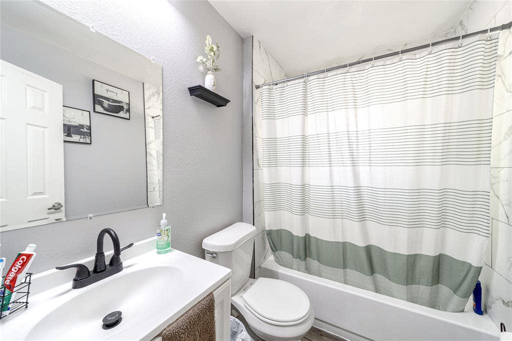 726 Royal Crest, Mesquite, TX 75149 Full bath featuring vanity, a textured wall, and shower / bathtub combination with curtain