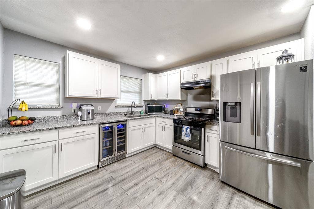 726 Royal Crest, Mesquite, TX 75149 Kitchen featuring stainless steel appliances, wine cooler, white cabinets, recessed lighting, and light stone countertops