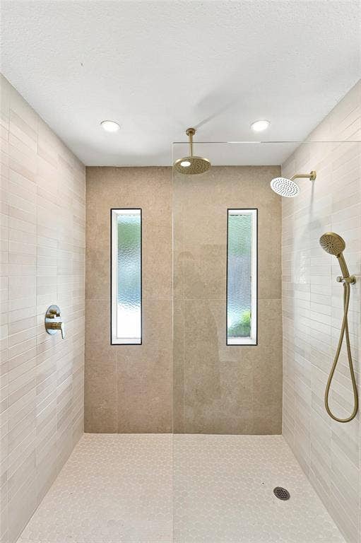 2411 Aspen Street, Richardson, TX 75082 Walk-in shower with dual shower heads, recessed lighting, two vertical windows, and hexagon tile flooring