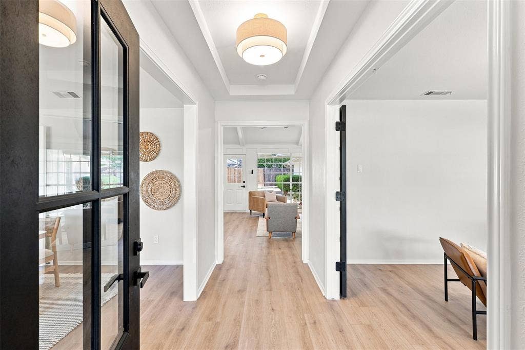 2411 Aspen Street, Richardson, TX 75082 Light wood-finish flooring extending throughout, coffered ceiling, recessed lighting, and a black-framed glass panel door