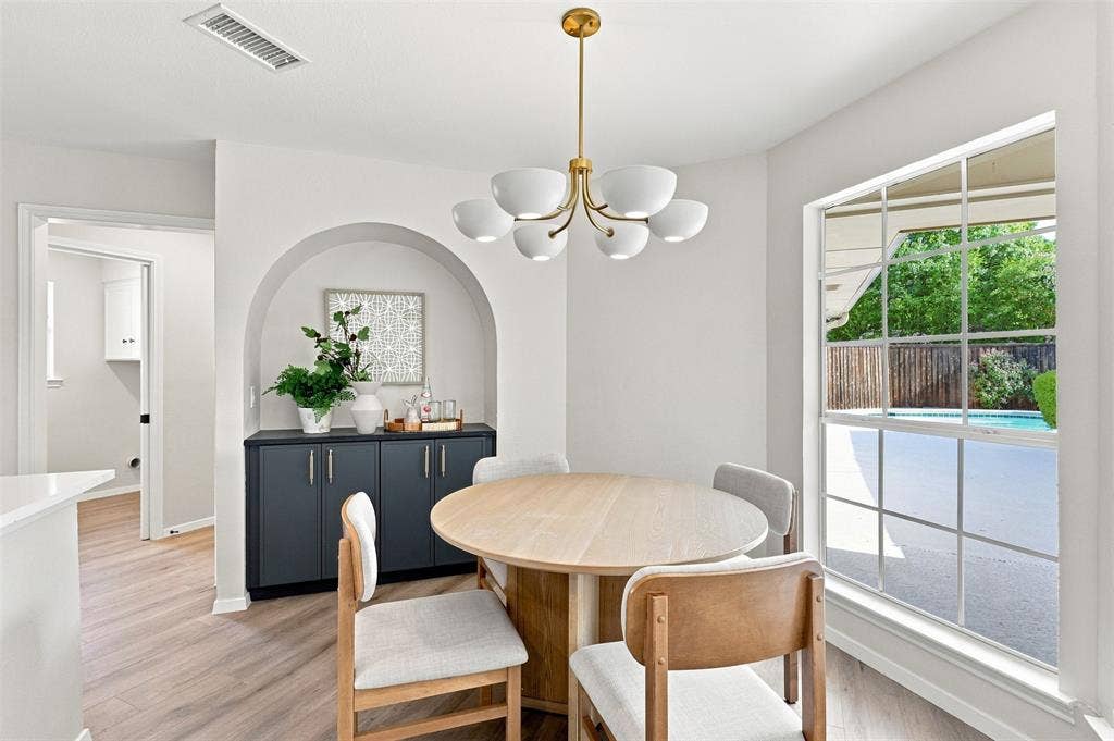 2411 Aspen Street, Richardson, TX 75082 Arched built-in cabinetry with a countertop, wood-finish flooring, and a multi-bulb chandelier