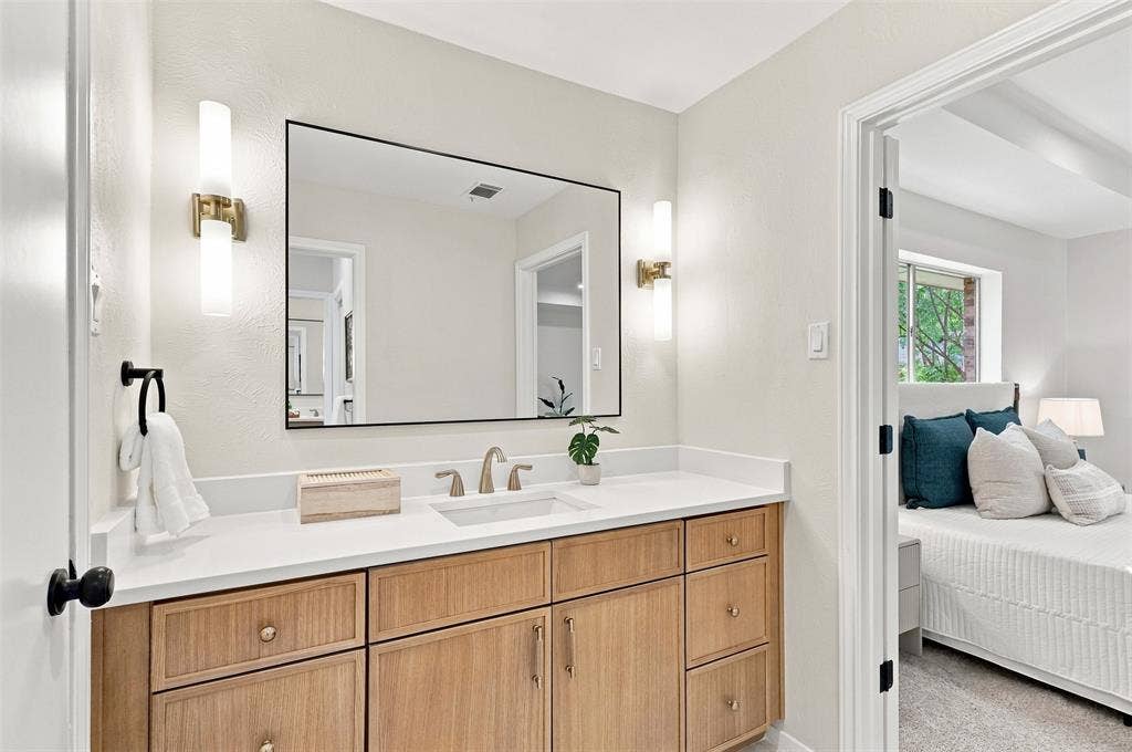 2411 Aspen Street, Richardson, TX 75082 Wood-finish vanity with a white countertop and undermount sink