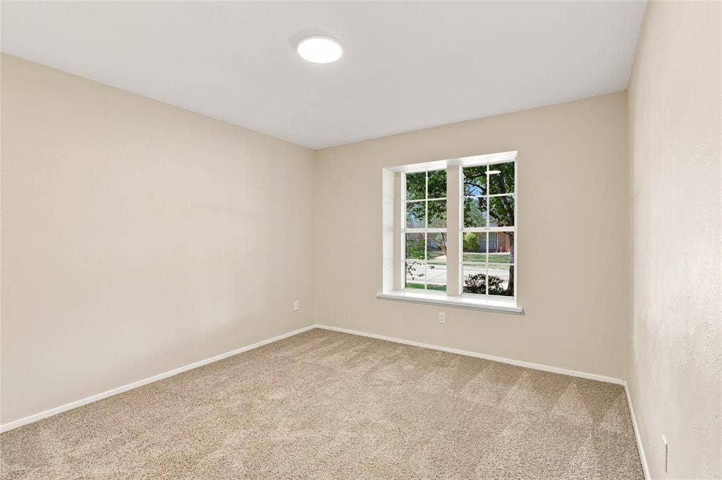 2411 Aspen Street, Richardson, TX 75082 Neutral-toned carpeting, light-colored wall paint, and a window with white trim