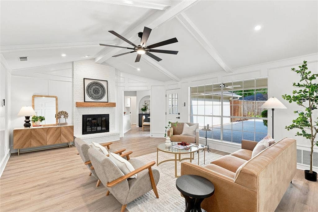 2411 Aspen Street, Richardson, TX 75082 Vaulted ceiling with exposed beams, brick fireplace with wood mantel, large pane windows, wood-finish flooring, and recessed lighting