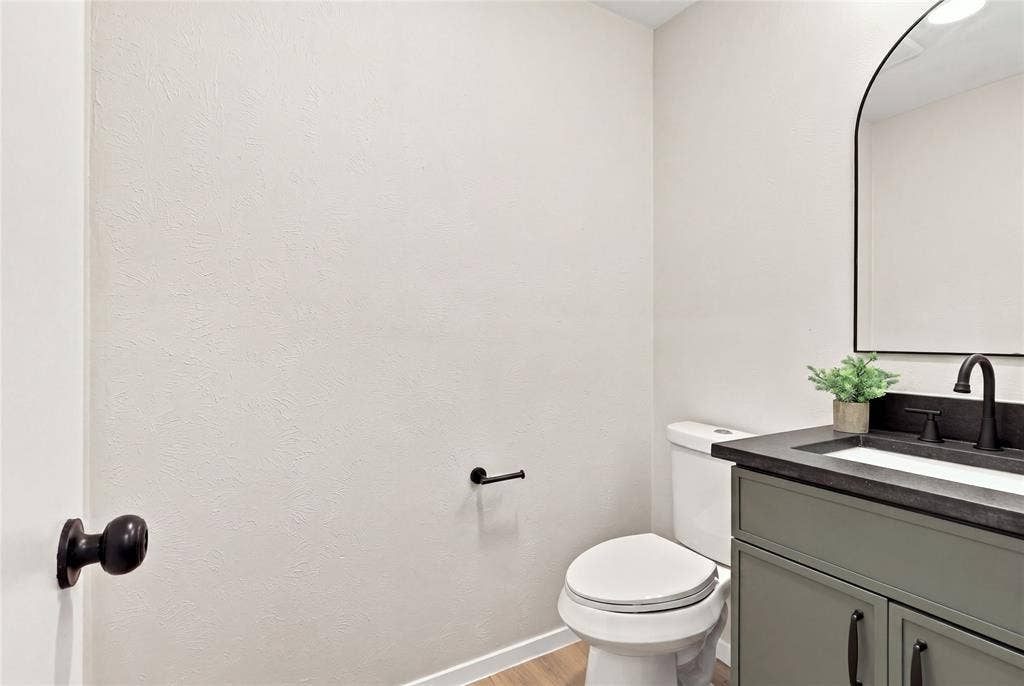 2411 Aspen Street, Richardson, TX 75082 Vanity with a dark countertop, white basin, and matte black faucet
