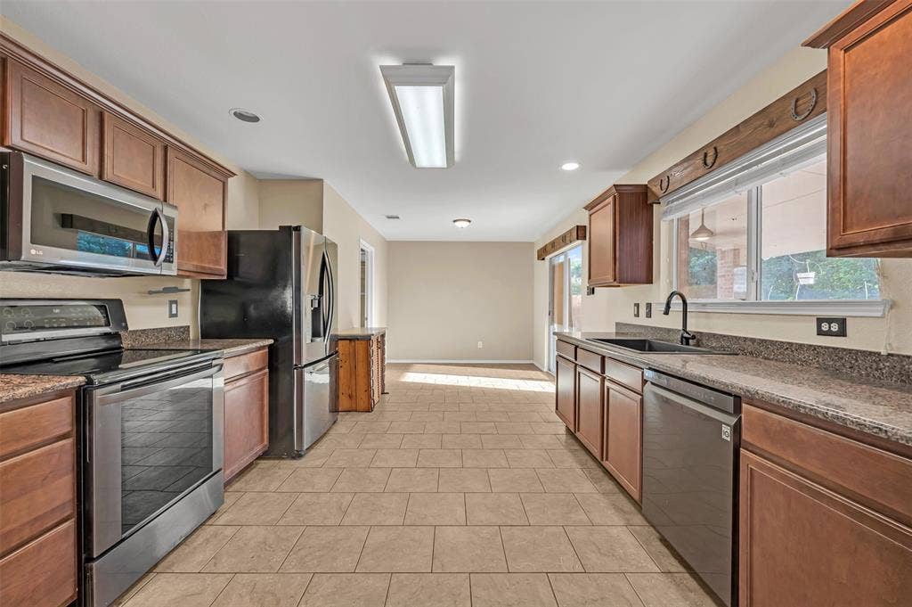 9017 Graywolf Ridge Trail, Fort Worth, TX 76244 Kitchen featuring sink, light tile floors, and stainless steel appliances