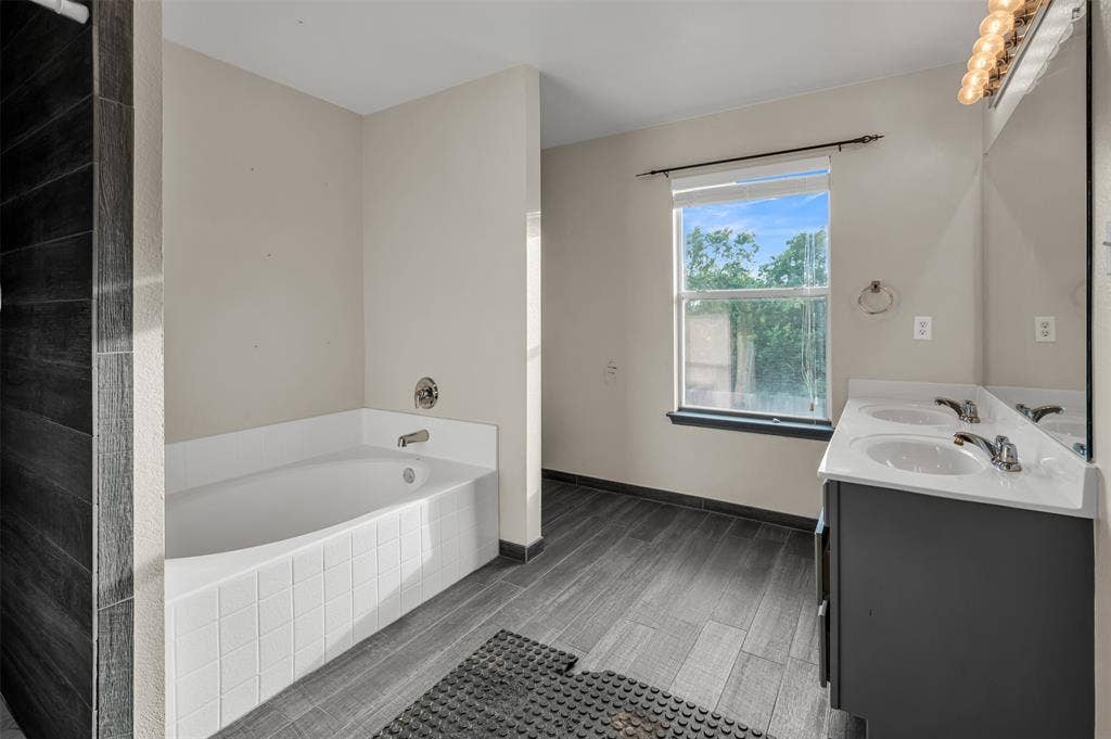 9017 Graywolf Ridge Trail, Fort Worth, TX 76244 Bathroom featuring dual bowl vanity and tiled tub