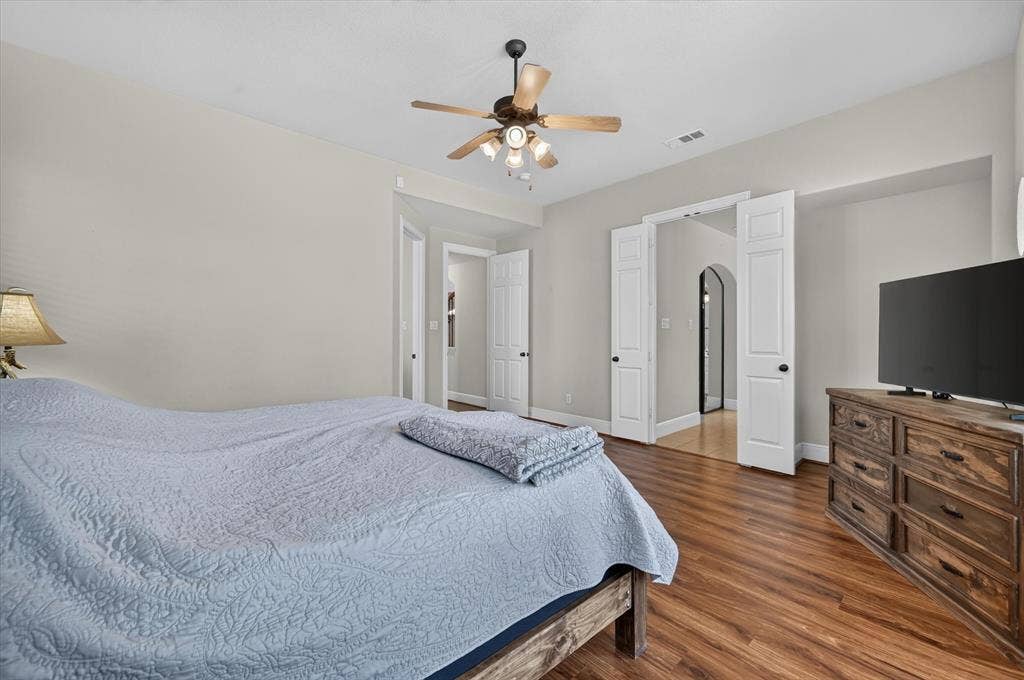 4612 Quiet Circle, Plano, TX 75024 Vaulted ceiling with a ceiling fan, wood-finish flooring, light-toned walls, and white interior doors