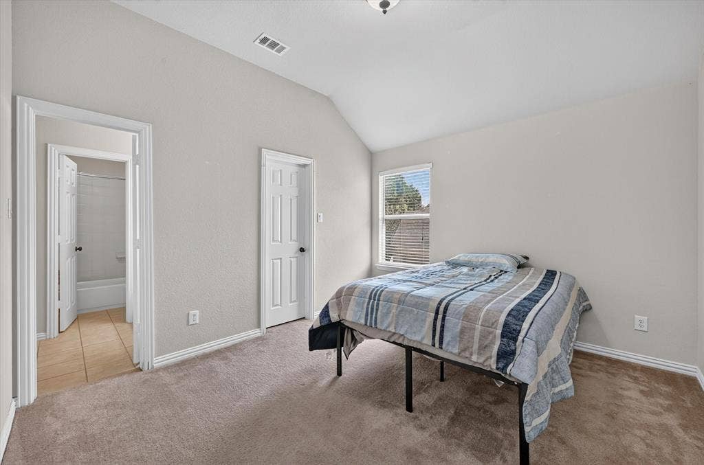4612 Quiet Circle, Plano, TX 75024 Vaulted ceiling, carpeted flooring, window with blinds, panel doors, and a bathroom with tile flooring and a bathtub