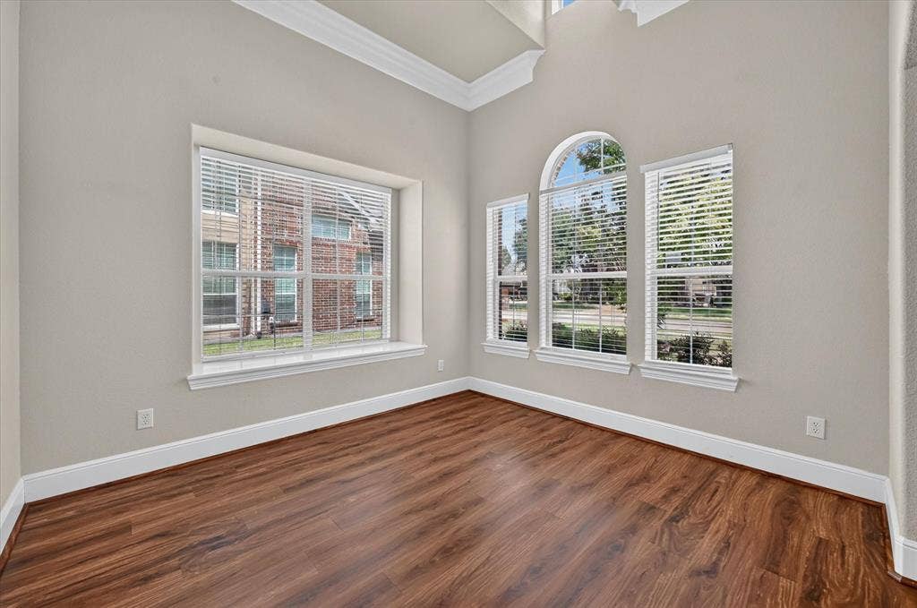 4612 Quiet Circle, Plano, TX 75024 Wood-finish flooring, high ceilings, crown molding, arched window, and multiple windows with blinds