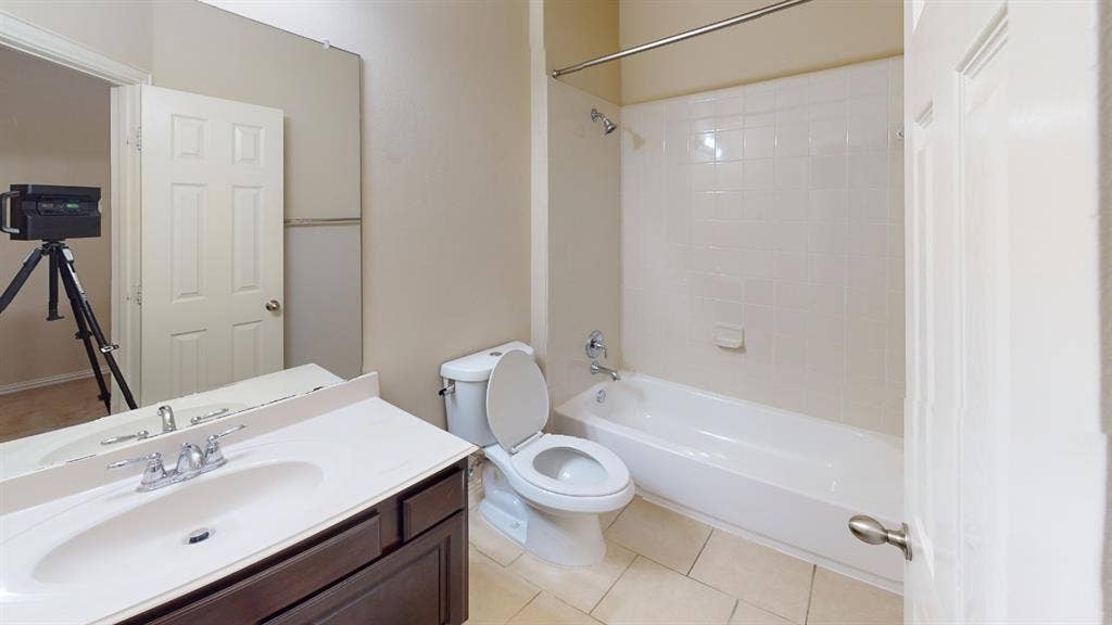 4651 Penelope Lane, Plano, TX 75024 White tile flooring, single vanity with dark wood-finish cabinetry, integrated sink, and chrome fixtures