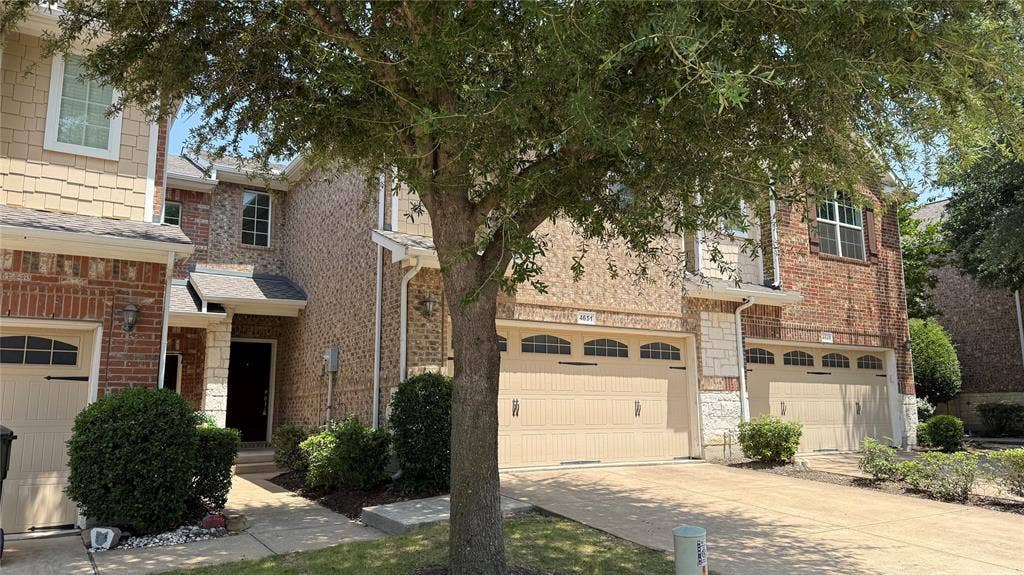 4651 Penelope Lane, Plano, TX 75024 Brick and stone facade with shake siding accents, multiple bay garage doors with arched window details, and mature landscaping