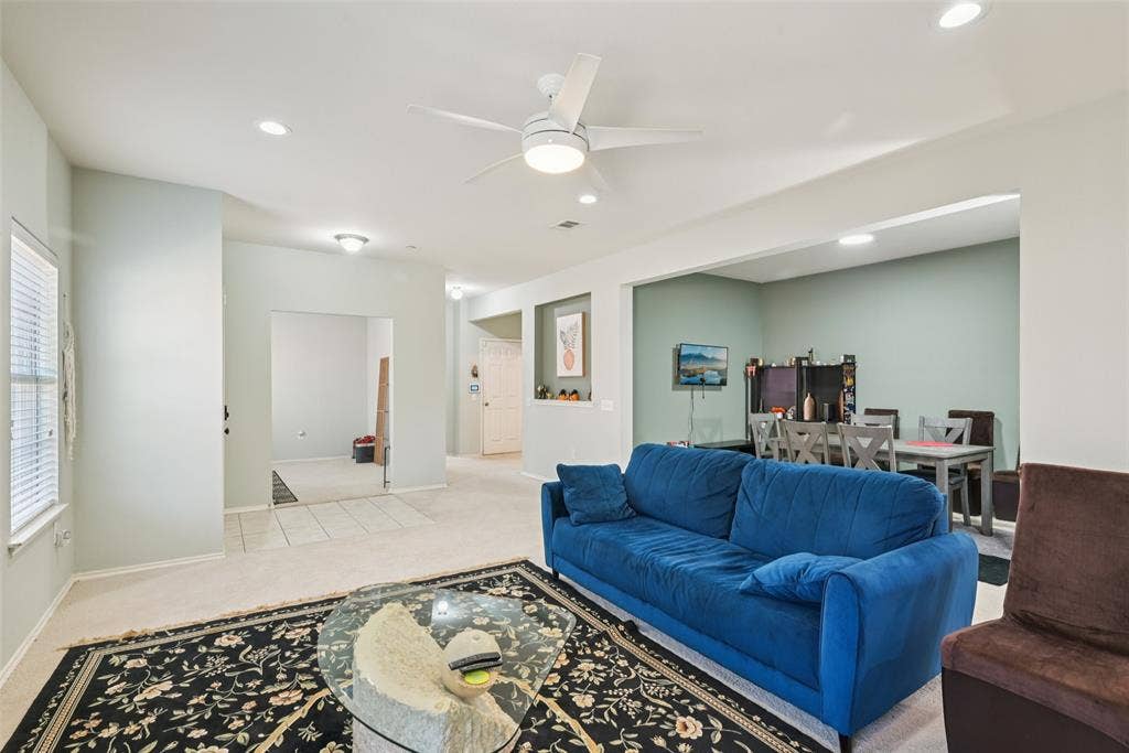 Recessed lighting, ceiling fan, carpet flooring, window with blinds, and arched doorways