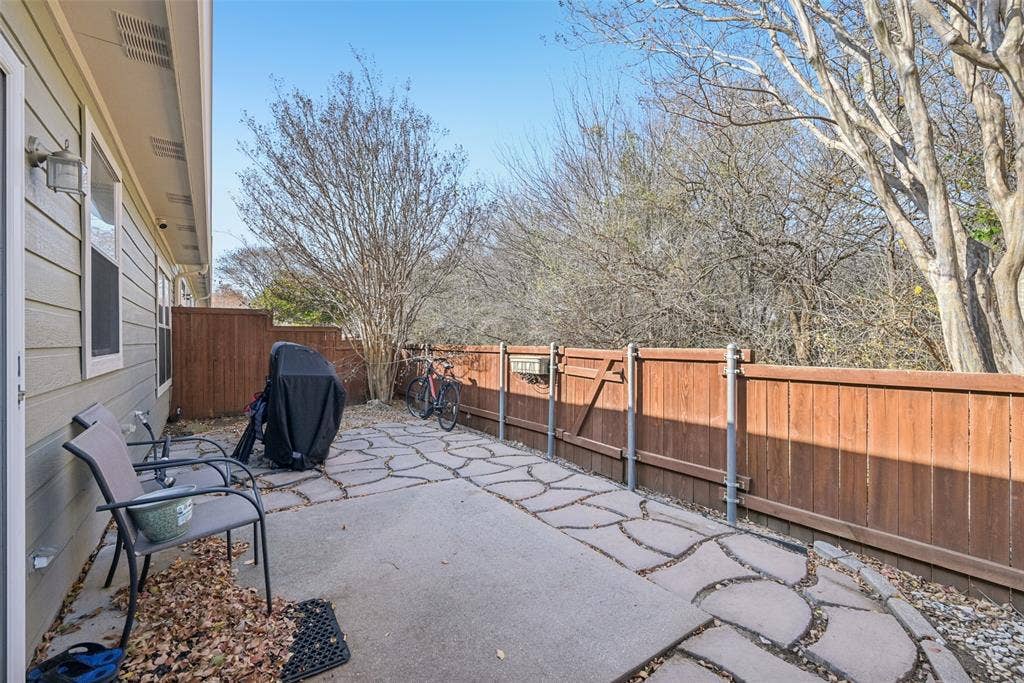 Stone paver patio with a wood privacy fence