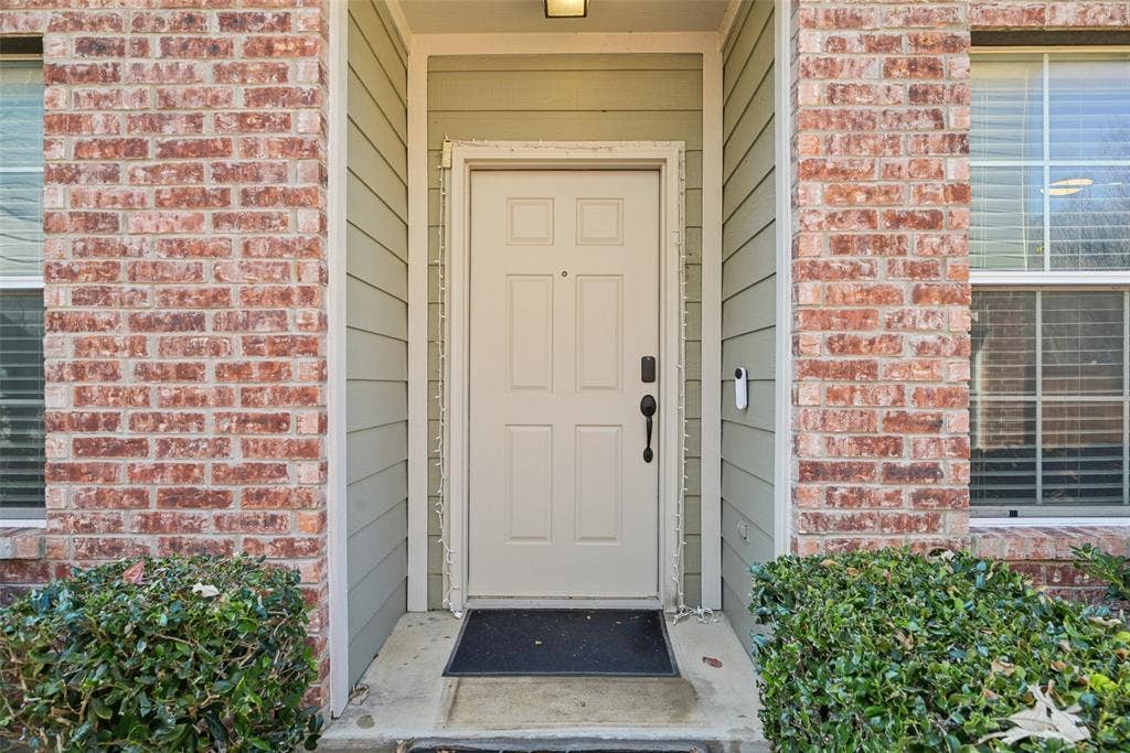 Brick facade with paneled entry door and horizontal siding accents