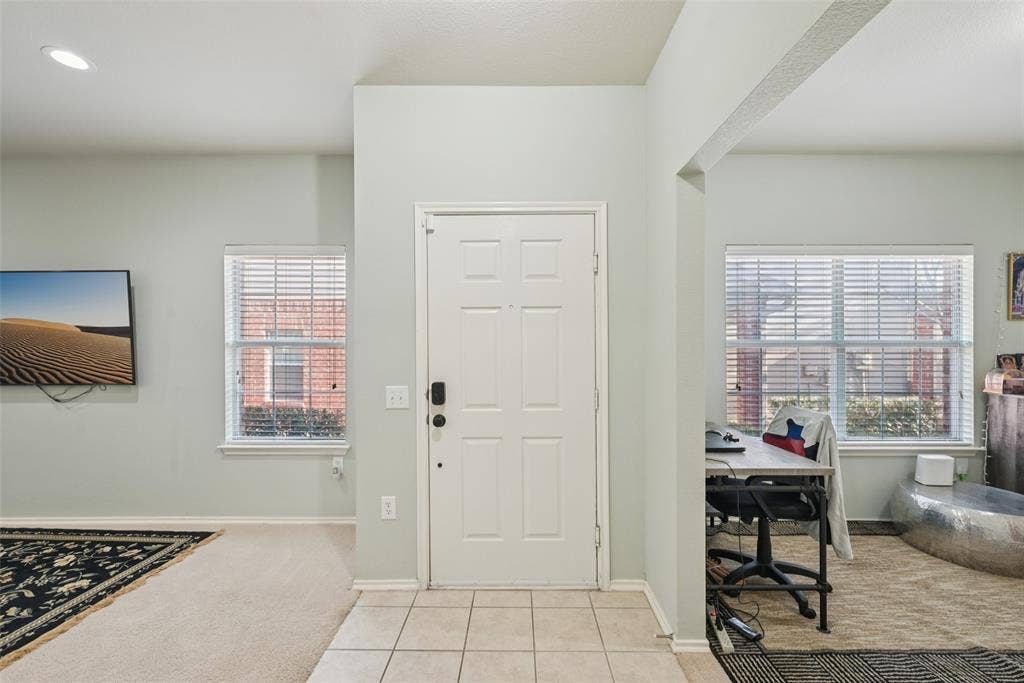 Recessed lighting, tile flooring entryway, paneled entry door, arched doorway, and windows with blinds