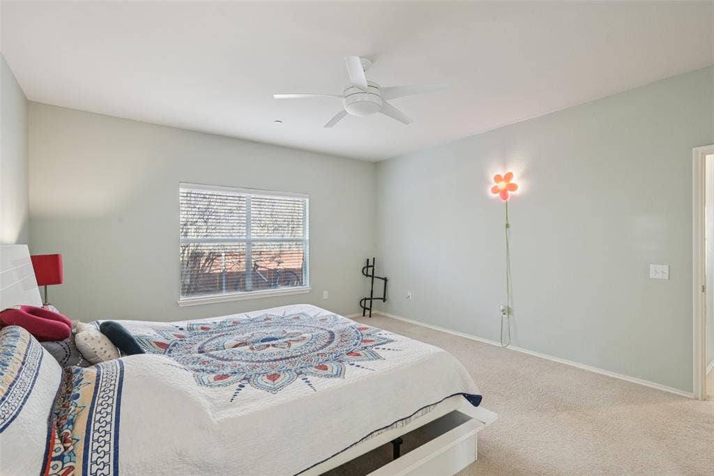 Carpeted flooring, vaulted ceiling, ceiling fan, window with blinds, and white trim