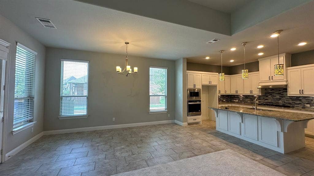 Living area featuring a fireplace with a mantel, flanking built-in shelving, a ceiling fan with integrated lighting, and recessed ceiling lights