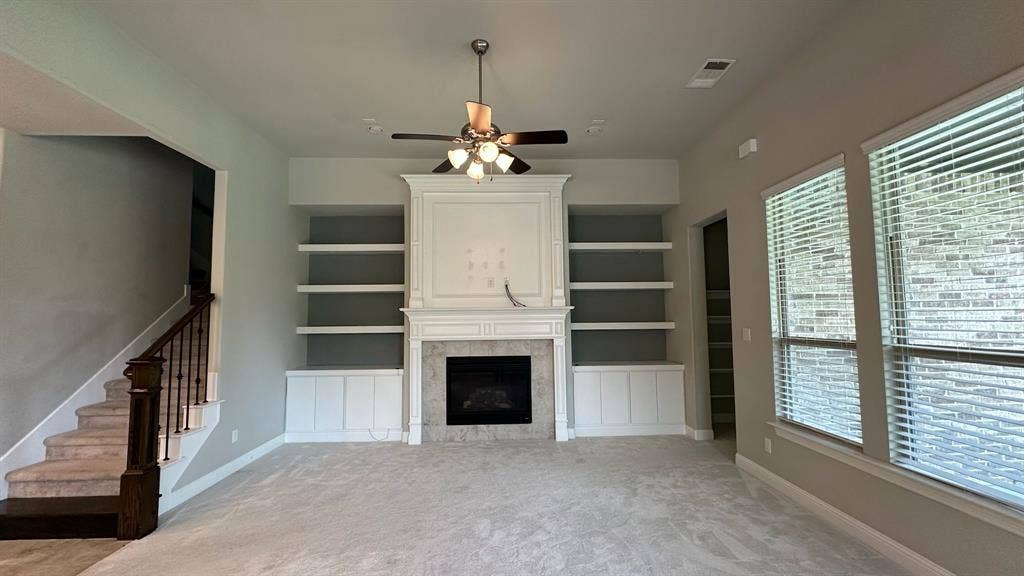 Spacious kitchen featuring white cabinetry, a large center island with a granite countertop, a tile backsplash, and stainless steel built-in appliances