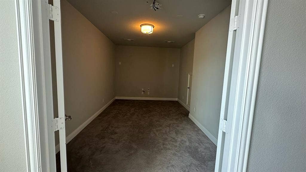 Spacious upper-level room featuring vaulted ceilings, ceiling fan with integrated lighting, expansive triple-window configuration with plantation shutters, neutral carpet flooring, and generous square footage ideal for multiple uses