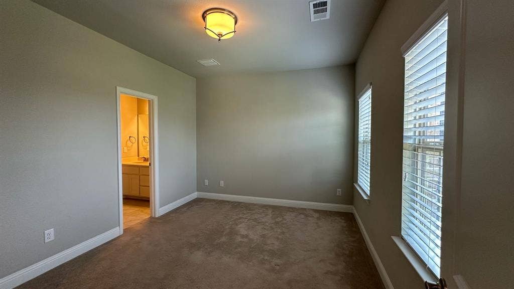 Carpeted room with neutral wall tones and a single window with blinds