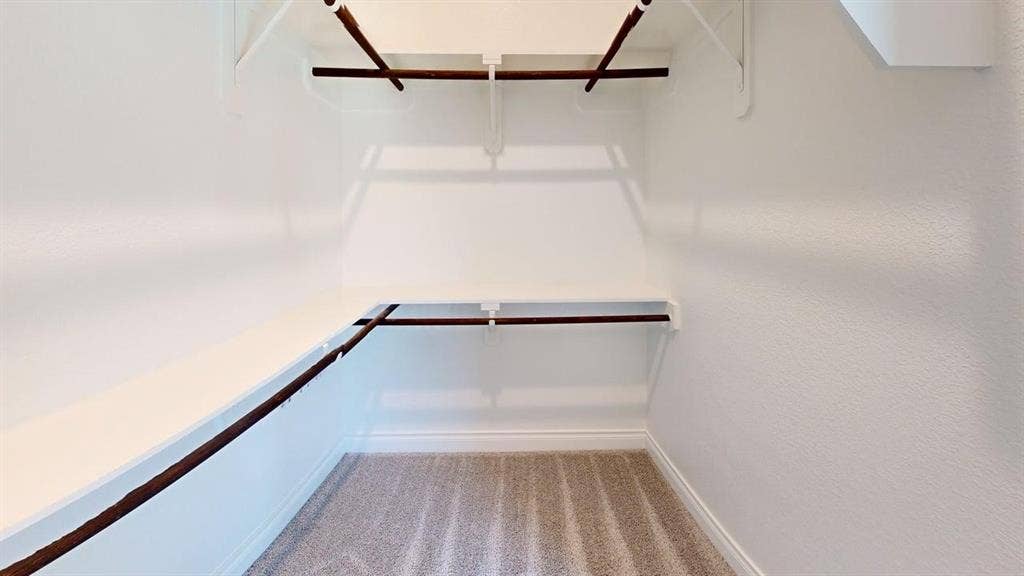 2401 Robin Way, Northlake, TX 76247 Built-in closet shelving system with multiple hanging rods and light-toned carpeting
