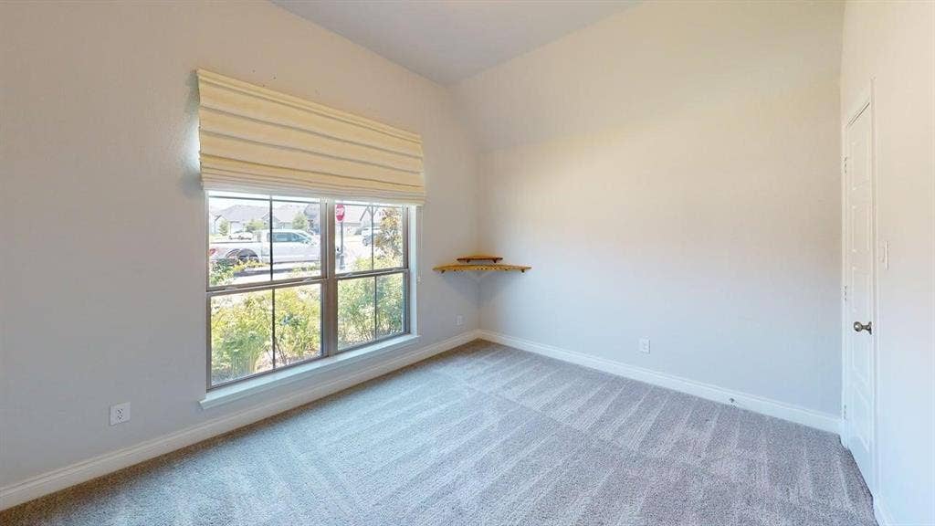 2401 Robin Way, Northlake, TX 76247 Vaulted ceiling, corner floating shelf, window with a Roman shade, light gray walls, and gray patterned carpeting