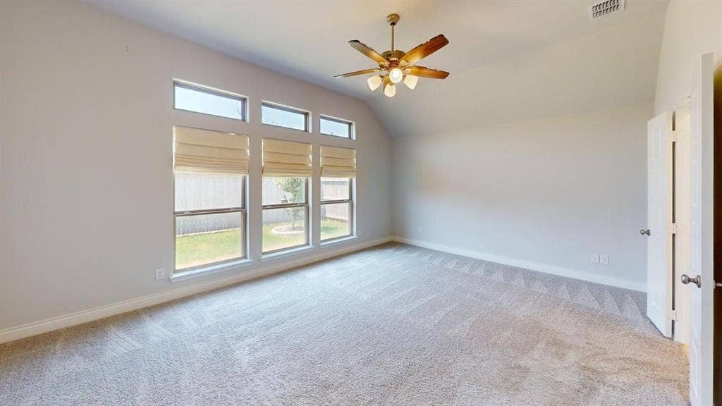 2401 Robin Way, Northlake, TX 76247 Vaulted ceiling with a ceiling fan, carpet flooring, a bank of four windows, and a hinged door