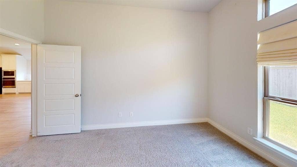 2401 Robin Way, Northlake, TX 76247 Carpeted room with high ceilings, a contemporary paneled door, and a multi-pane window with a fabric shade