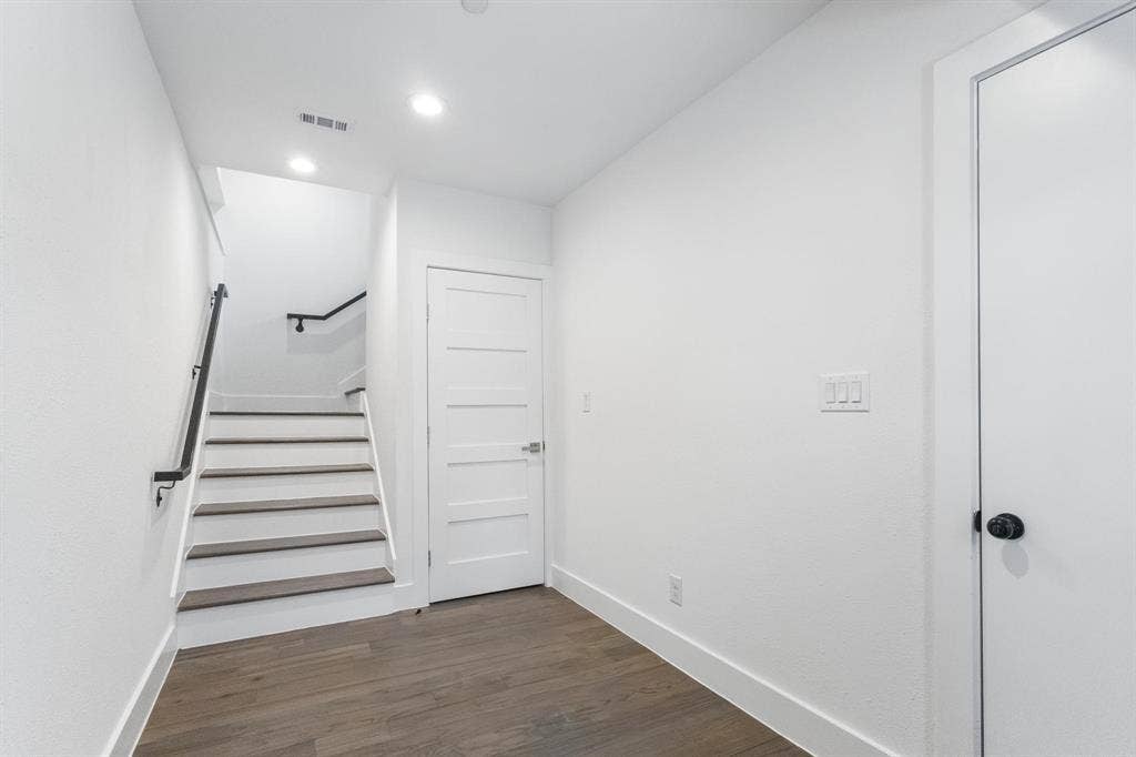 2450 N Garrett Avenue, #14, Dallas, TX 75206 First floor, Hardwood-finish flooring, recessed lighting, modern paneled interior doors, black metal handrail, and white walls