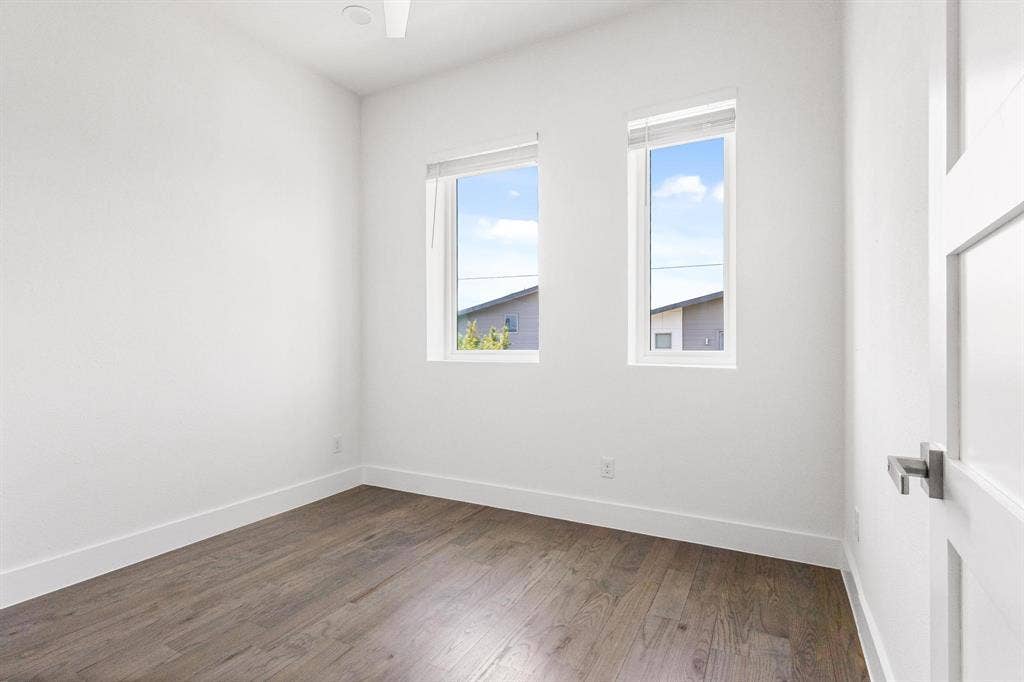 2450 N Garrett Avenue, #14, Dallas, TX 75206 Wood-finish flooring, white walls, and two rectangular windows with blinds