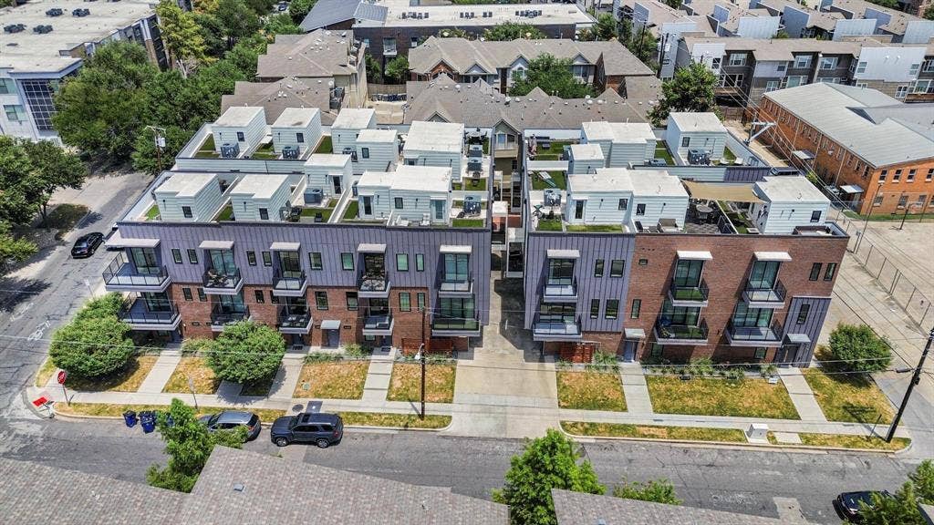 2450 N Garrett Avenue, #14, Dallas, TX 75206 Modern multi-story buildings featuring brick and vertical siding exteriors, private balconies with dark railings, and rooftop terraces