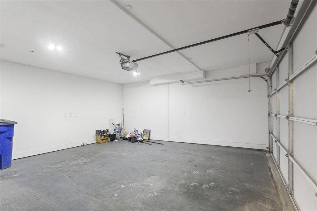 2450 N Garrett Avenue, #14, Dallas, TX 75206 Attached garage with a concrete floor, white walls, and overhead lighting