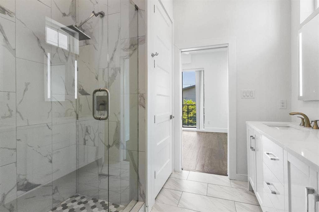 2450 N Garrett Avenue, #14, Dallas, TX 75206 Glass-enclosed shower with a rainfall showerhead, large format wall tiling, and hexagonal floor tiling