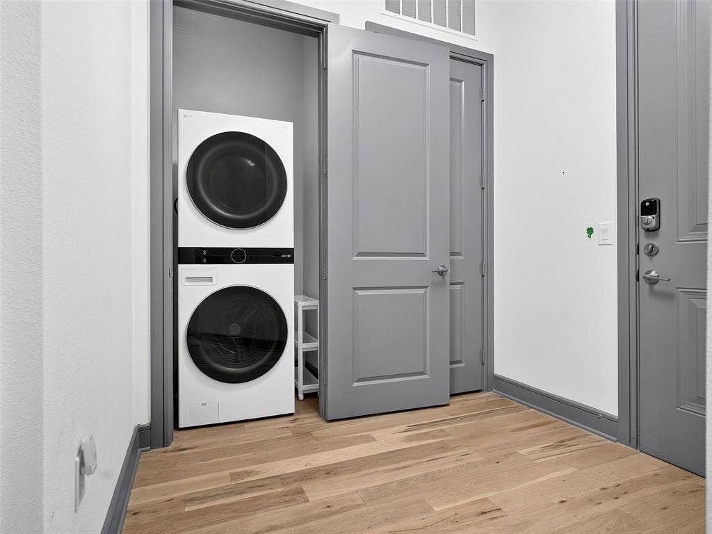 2700 Old Denton Road, #2212, Carrollton, TX 75007 Stackable washer and dryer unit, light wood-finish flooring, white walls, and gray trim