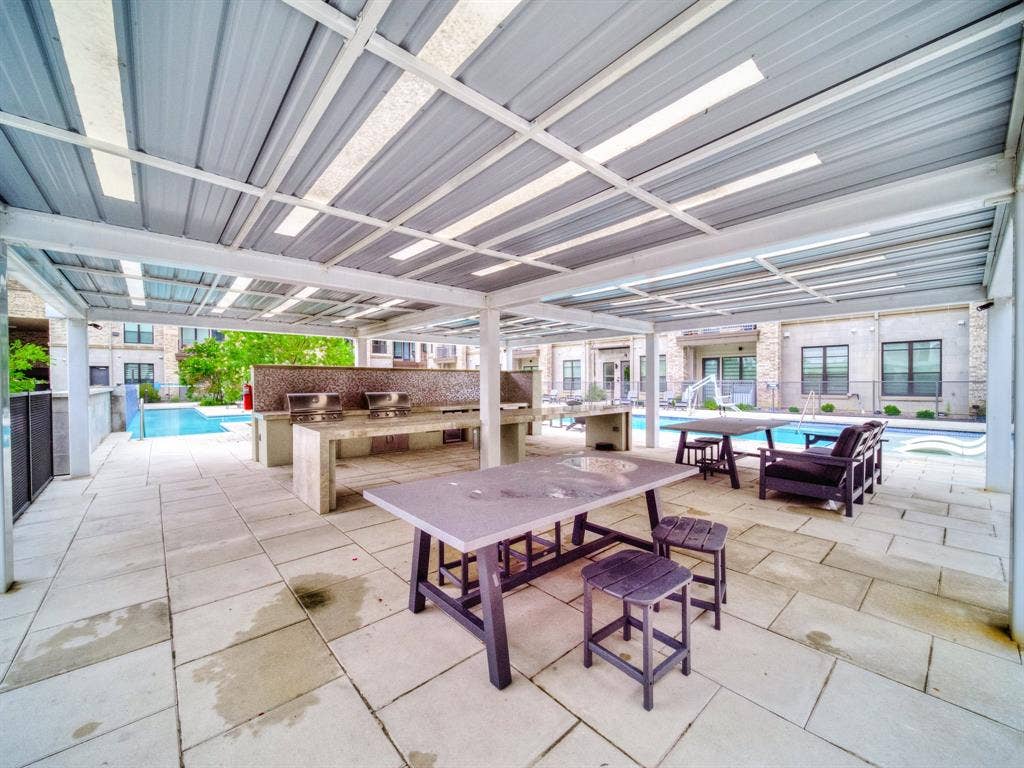 2700 Old Denton Road, #2212, Carrollton, TX 75007 Covered outdoor patio with a tiled floor, built-in grill stations, and a swimming pool