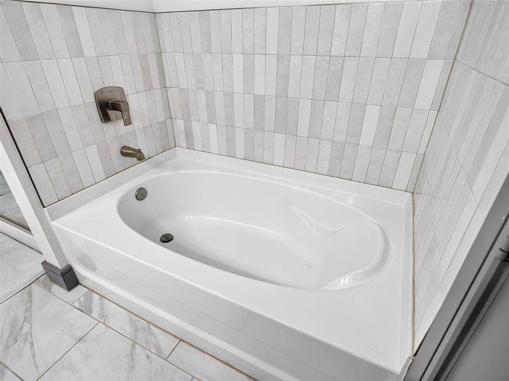 2700 Old Denton Road, #2212, Carrollton, TX 75007 Built-in bathtub with a brushed nickel faucet and tile surround