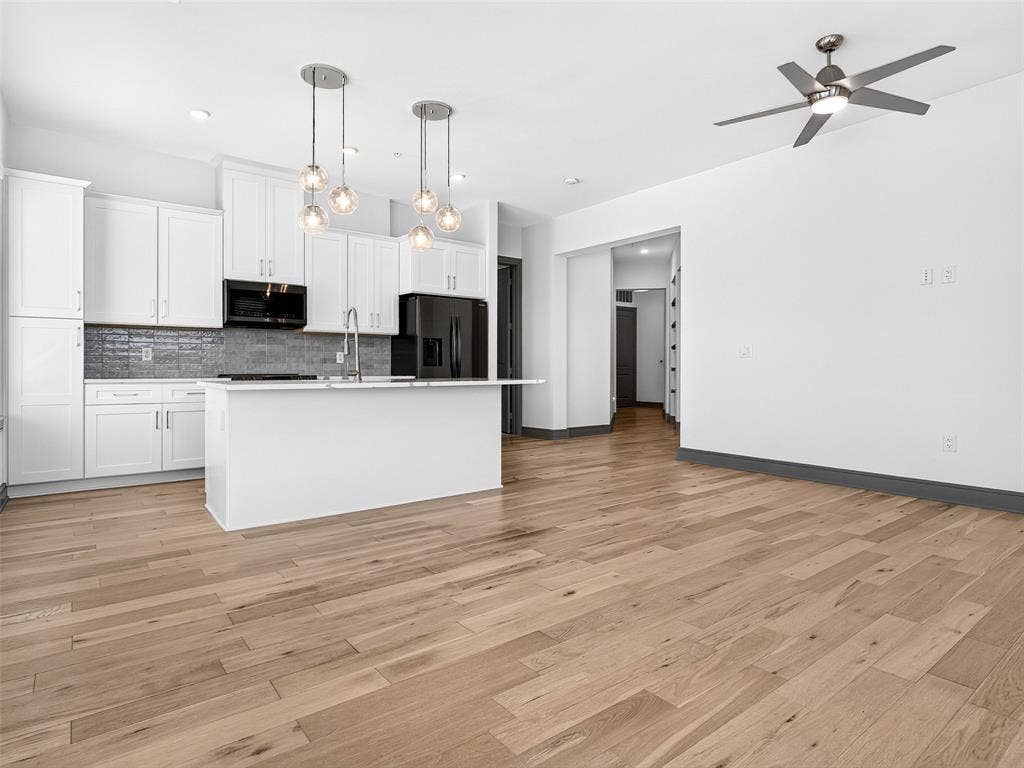2700 Old Denton Road, #2212, Carrollton, TX 75007 Open-concept living space with light wood-finish flooring, white walls, and a modern ceiling fan